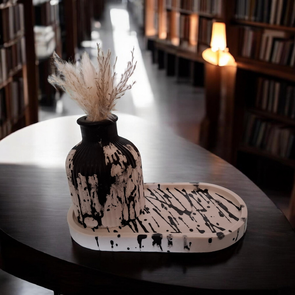 un plateau blanc rayé noir avec son petit vase